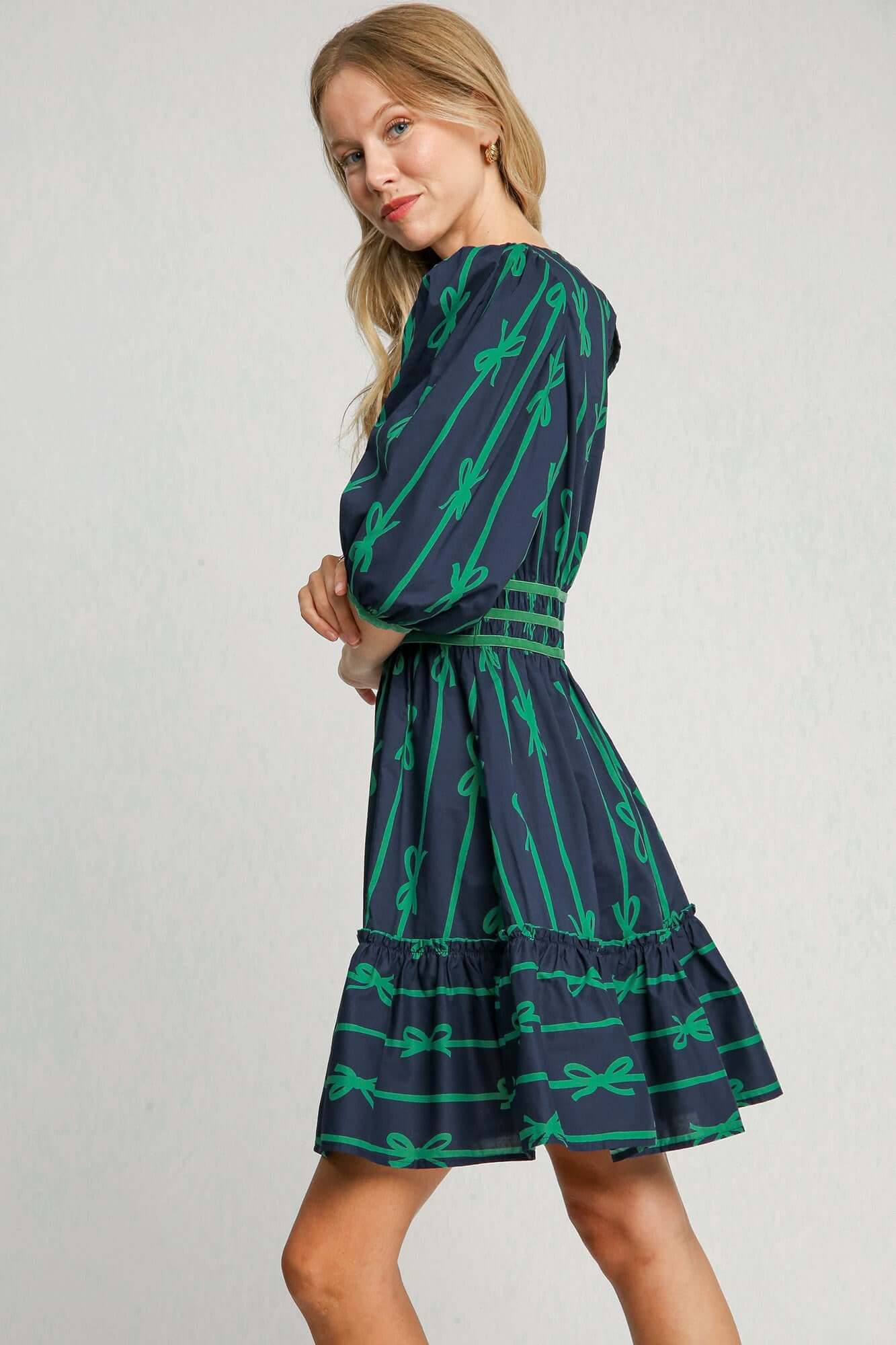 Woman in a stylish ribbon print frill dress with velvet trim, perfect for chic events and special occasions.