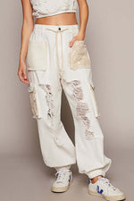 White crochet patch distressed jeans with unique textures, perfect for a trendy bohemian look.