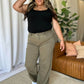 High rise garment dye wide leg jeans in khaki color worn by a woman, paired with a black top, creates a stylish and comfortable look.