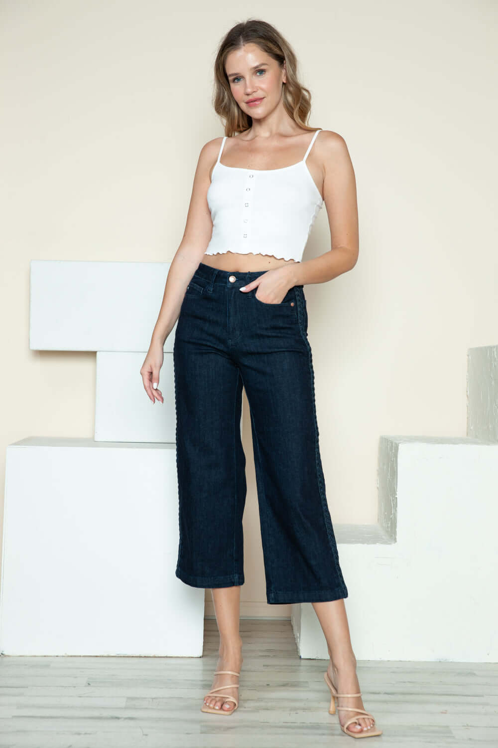 Woman wearing Judy Blue crop wide-leg jeans with side seam braid and white top.