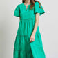 Woman wearing green HEYSON cotton poplin ruffled tiered midi dress, perfect for summer occasions.