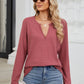 Woman wearing a Bella Road Waffle-Knit Notched Long Sleeve T-Shirt in pink paired with blue jeans and sunglasses.