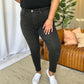 Woman wearing RFM Full Size High Rise Tummy Control Skinny Jeans in black, showcasing the flattering high-waist design and sleek fit.