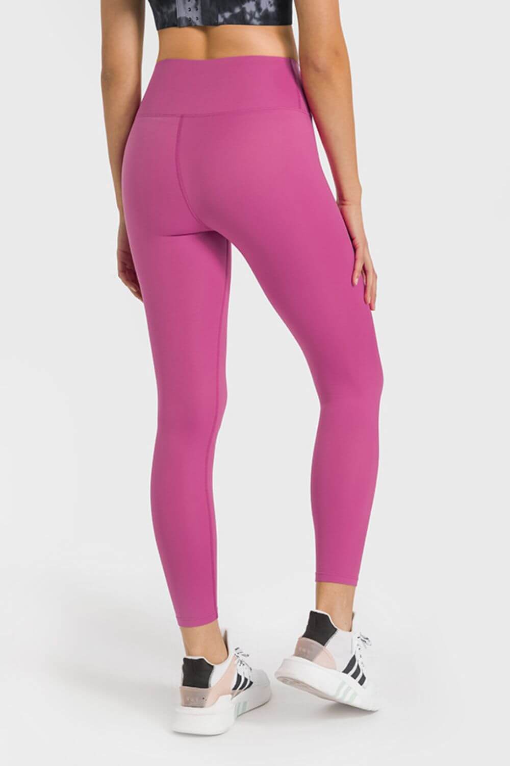 Back view of Millennia high waist ankle-length yoga leggings in vibrant pink, perfect for workouts and yoga sessions.