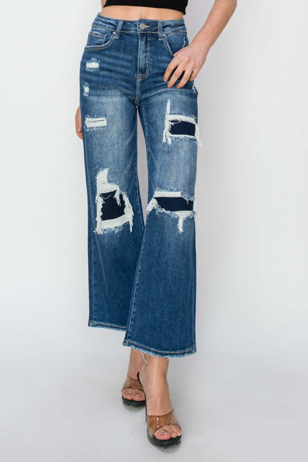 High rise patch detailed wide leg crop jeans in dark blue denim. Trendy Risen Jeans with edgy patches and flattering silhouette for a modern look.