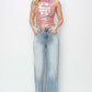 Woman wearing high rise wide leg Risen Jeans and pink metallic top for a chic and stylish look.