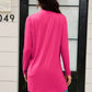 Woman wearing a pink open front long sleeve cardigan with pockets, standing in front of a door.