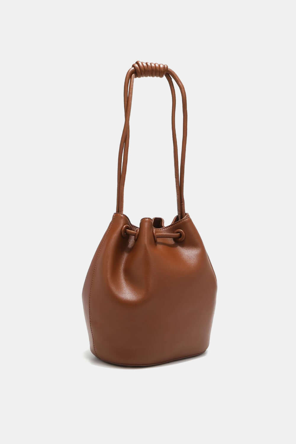 Brown drawstring bucket bag crafted from pebbled vegan leather with knotted handle.