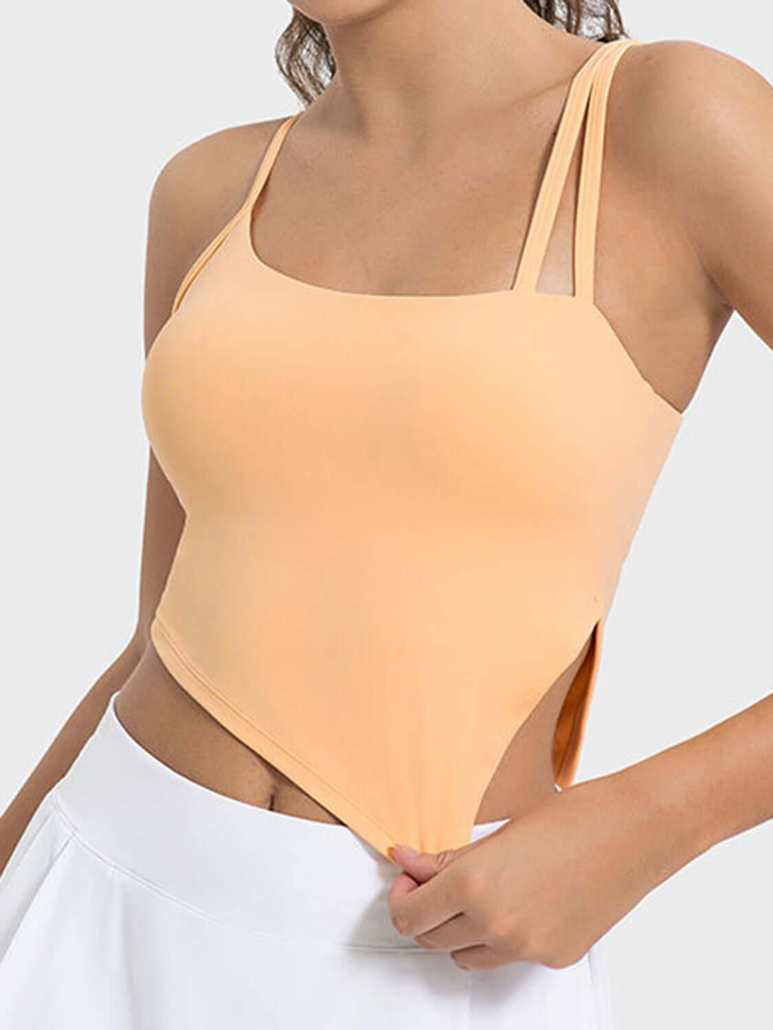 Millennia Slit Asymmetrical Neck Active Cami in peach with stylish slits and sleek straps for workouts.