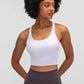 Stylish woman wearing a white Millennia Racerback Sports Bra, ready for yoga, showcasing comfort and sporty design.