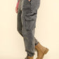 Woman wearing VERY J washed drawstring jogger cargo jeans with side pockets, elastic waist, and boots, showcasing comfortable style.