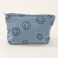 Cute blue corduroy clutch bag featuring a playful smiley face print, perfect for casual outings and adding style.