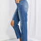 Side view of Emily High Rise Relaxed Jeans with ripped knee detail, casual solid blue Risen Jeans for a timeless and edgy look.