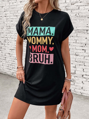 Woman wearing a black short sleeve mini tee dress with colorful "MAMA. MOMMY. MOM. BRUH." graphic text.