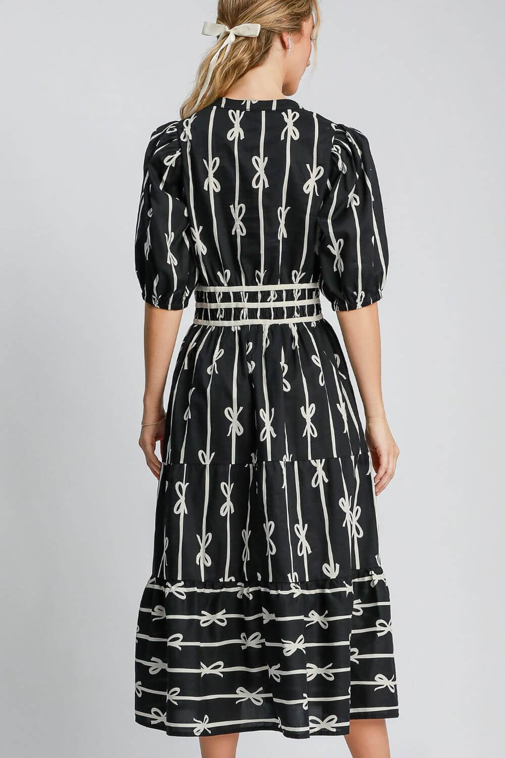 Back view of Umgee bow tie print midi dress featuring a notched neckline and velvet trim, perfect for elegant occasions.