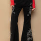 Black raw hem embroidered flare pants with a bohemian vibe, paired with a stylish red top and sneakers.