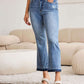 Woman wearing Judy Blue release hem cropped bootcut jeans with a modern silhouette and edgy design.