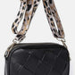 Stylish black Cassette Woven Crossbody Bag with a leopard print adjustable strap for hands-free convenience.