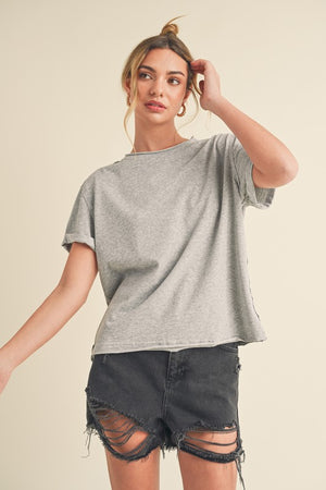 Aemi + Co exposed seam round neck short sleeve t-shirt styled with distressed black shorts for a casual look.