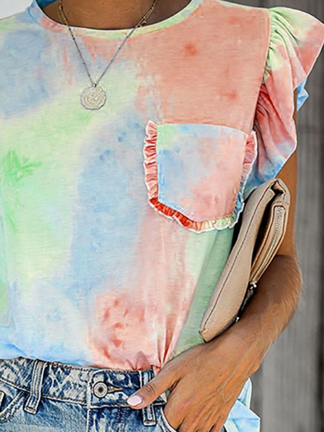 Bella Road Ruffled Printed T-Shirt with cap sleeves in pastel colors, featuring a pocket and worn with denim jeans.