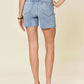 Woman wearing High Waist Raw Hem Denim Shorts by Judy Blue Jeans, back view.