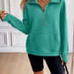 Woman wearing Ivy Lane Half Zip Raglan Sleeve Sweatshirt in green with pockets, no stretch, 100% polyester material