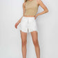 Woman wearing Risen Jeans Button Fly Frayed Hem Denim Shorts with a beige crop top and sandals, striking a casual pose.