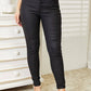 High Rise Black Coated Ankle Skinny Jeans with exposed button closure, crafted from stretch denim for a figure-hugging fit.