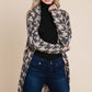 Woman wearing a BOMBOM houndstooth open front cocoon knit cardigan over a black top and jeans.