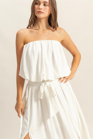 Stylish woman in a white bubble hem tube top, perfect for warm weather and versatile layering.