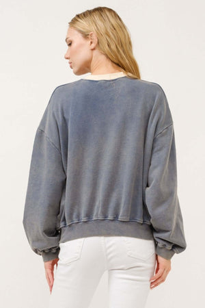 Woman wearing a stylish contrast crop sweatshirt with a casual, laid-back vibe, perfect for pairing with high-waisted bottoms.