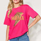 Woman wearing a pink MAMA round neck short sleeve T-shirt with leopard print design, paired with blue jeans.