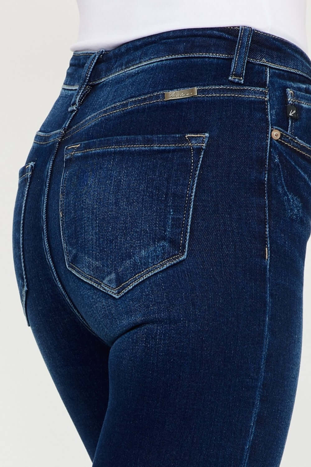 Close-up of high rise frayed ankle skinny jeans back pocket detailing