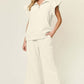 Woman wearing Texture Ruffle Short Sleeve Top and Drawstring Wide Leg Pants Set in cream color, featuring pockets and a slightly stretchy fabric.