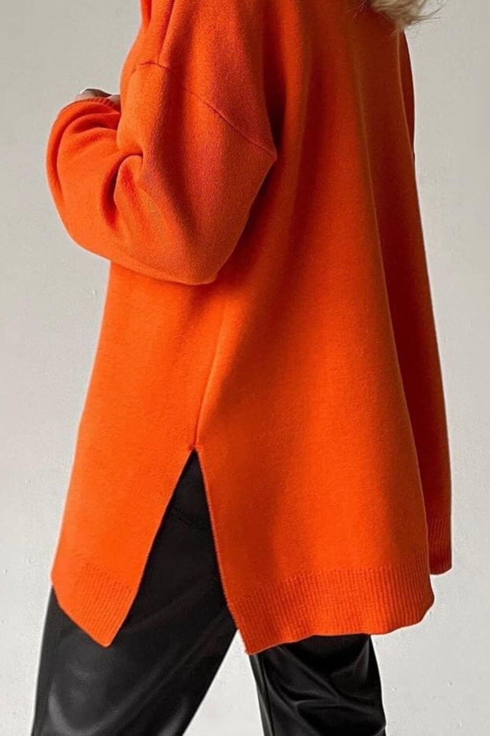 Cozy orange sweater with side slit, turtleneck, and dropped shoulders for a chic and relaxed style.