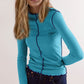 Model wearing Basic Bae Contrast Trim Mock Neck Long Sleeve T-Shirt in turquoise with blue trim.