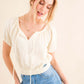 Woman wearing Back Waist Tie Cropped Blouse with high-waisted jeans, showcasing the stylish and versatile blouse with a flattering silhouette.