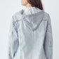 Back view of a woman in a distressed drawstring hooded denim jacket, perfect for a casual and stylish look.