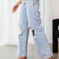 Woman wearing Bella Road Distressed Wide Leg Jeans with Pockets, shown with a side view highlighting the ripped details and loose fit.