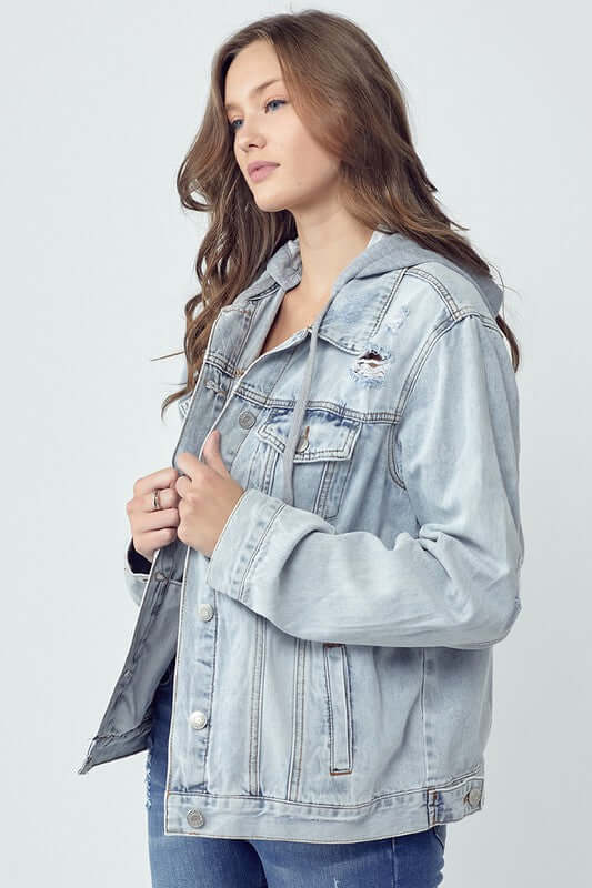 Young woman modeling a RISEN distressed drawstring hooded denim jacket in light wash, perfect for casual outfits.