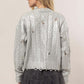 Woman wearing a HYFVE distressed cable-knit round neck sweater in silver, styled with a black skirt for a casual look.