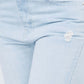 Close-up of high waist distressed raw hem jeans with trendy distressed detailing and modern raw hem finish.