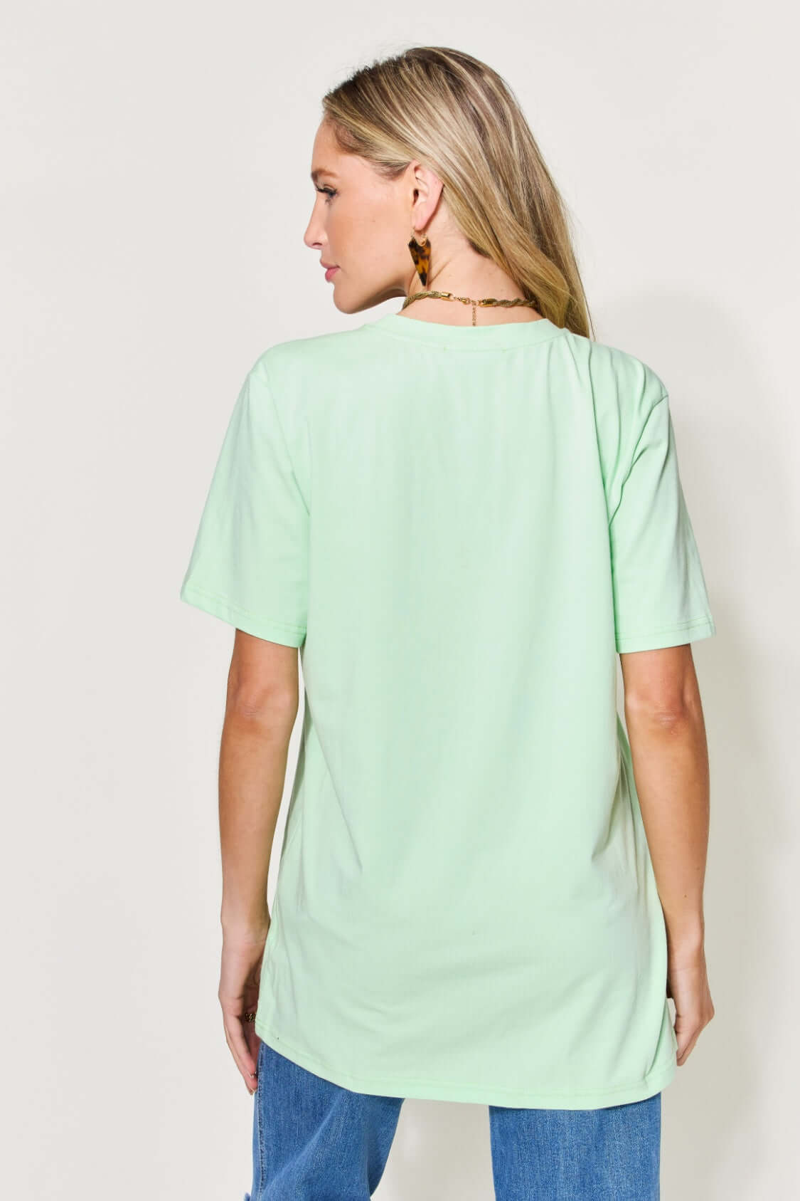 Woman wearing a MAMA round neck short sleeve t-shirt in green, back view.