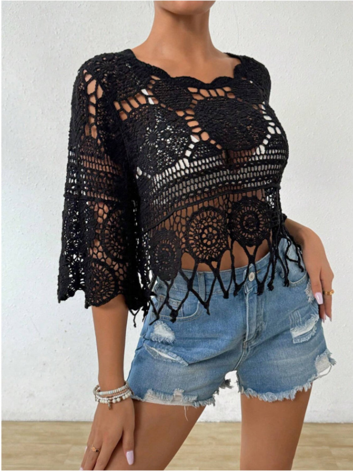 Black openwork round neck cover-up by Bella Road Swim, styled with denim shorts for a chic beach look.