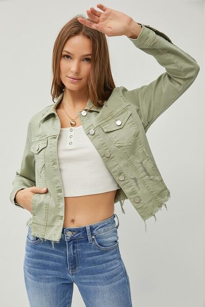 Model showcasing the RISEN cropped denim jacket with raw hem, styled with a casual top and jeans.