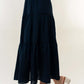 High Waisted Tiered Maxi Skirt in black, featuring a high-rise waist and flowy silhouette, paired with white top and braided sandals