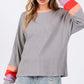 Woman wearing Color Block Waffle Knit T-Shirt with raglan sleeves and a contrast crew neckline. Stylish, casual, and cozy top.