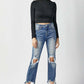 Model wearing High Waist Distressed Frayed Hem Cropped Straight Risen Jeans, black turtleneck, and black heels against a white background