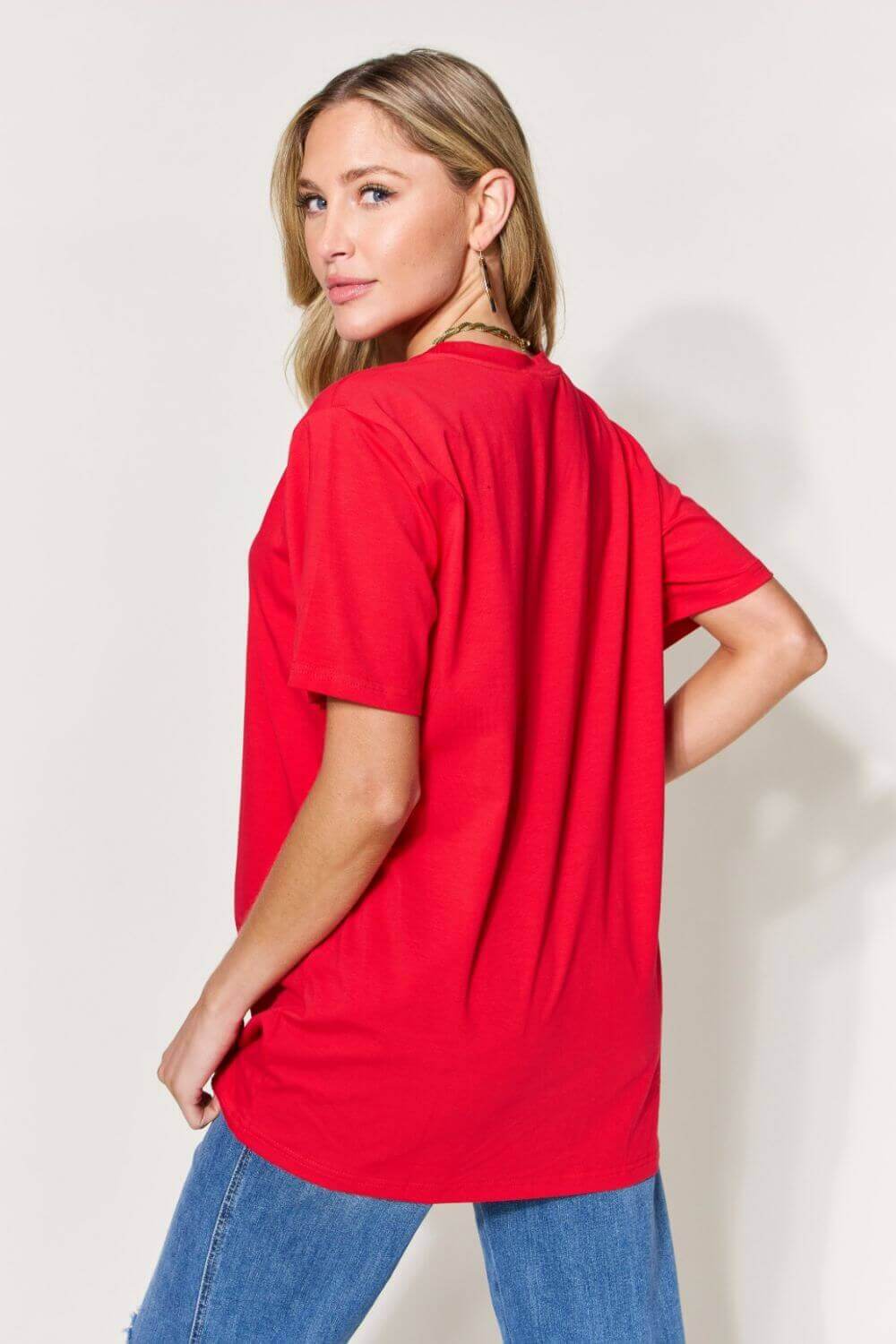 Woman wearing a red graphic round neck short sleeve t-shirt with slightly stretchy material, shown from the back.