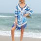 Woman wearing a blue Cutout V-Neck Three-Quarter Sleeve Cover Up with tassels, standing on the beach.